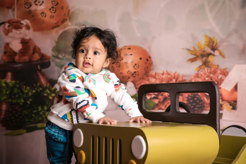 an adorable little  standing in front of a toy truck