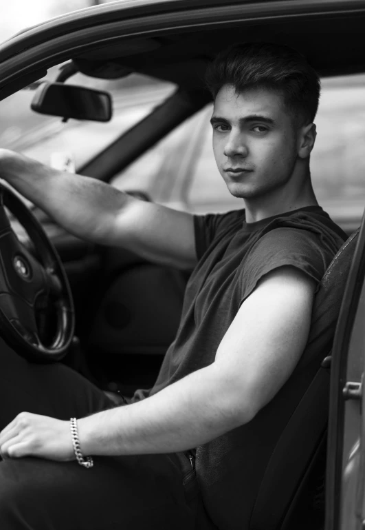 a man sitting in a car while wearing an celet