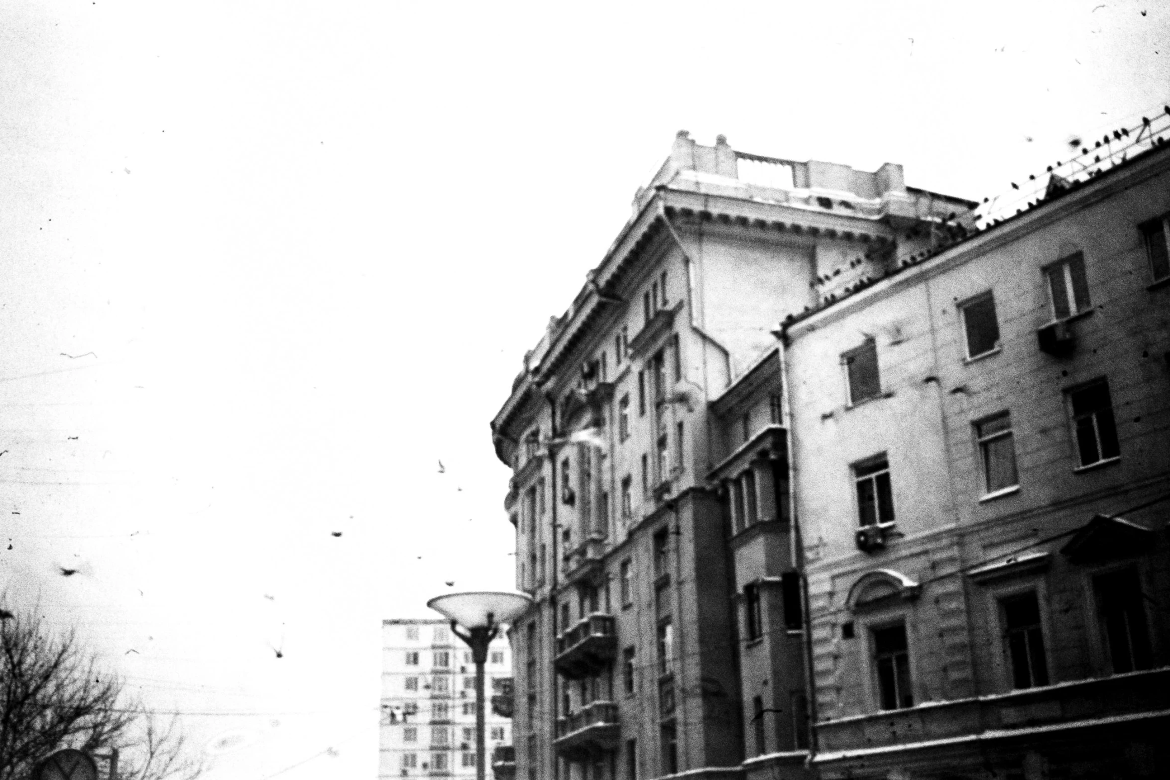 a city scene with buildings, street lamps, and people