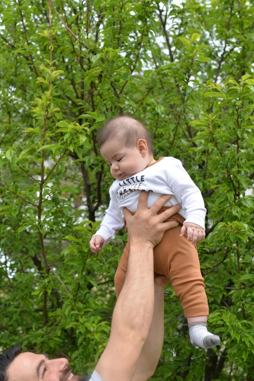 there is a man holding up a baby