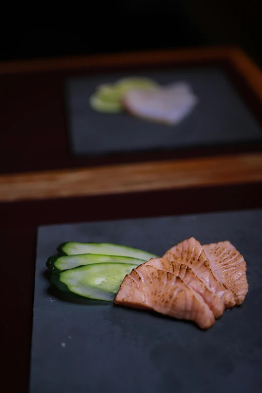 fish and cucumbers sitting on black  board