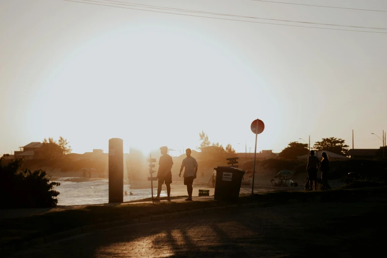 there are two people standing on the street near a street sign