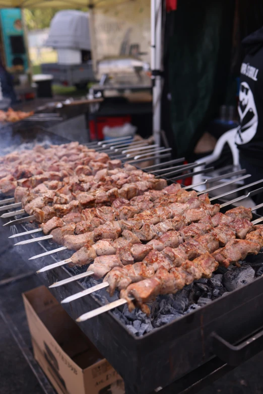 a grill with skewers of food cooking on a charcoal grill