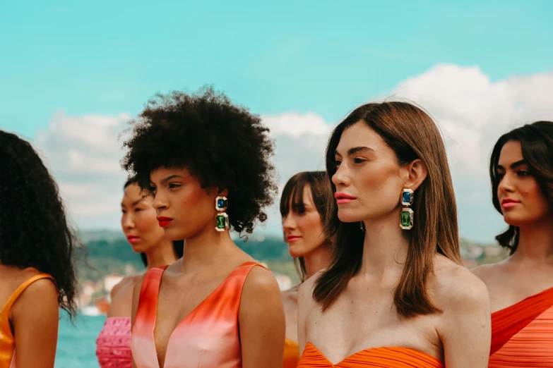 models posing on the beach in orange and orange dresses