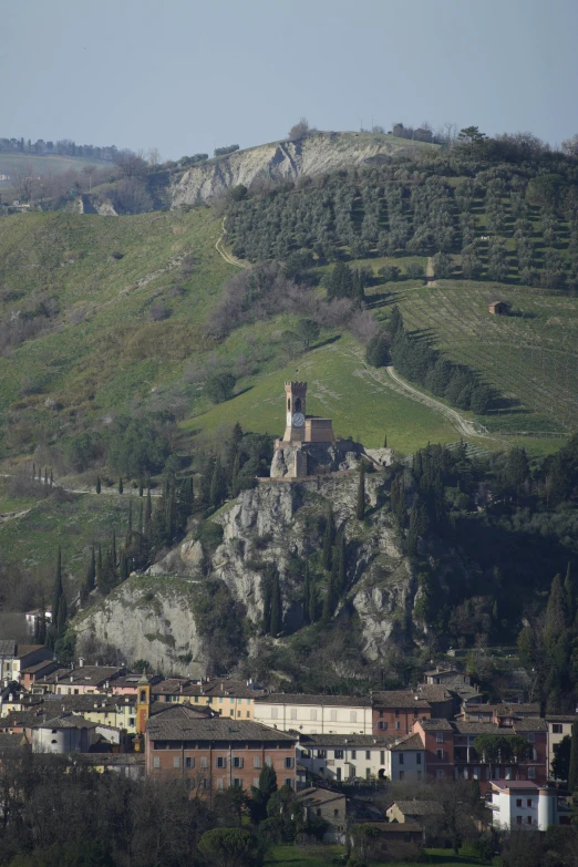 a village on a hill with lots of trees