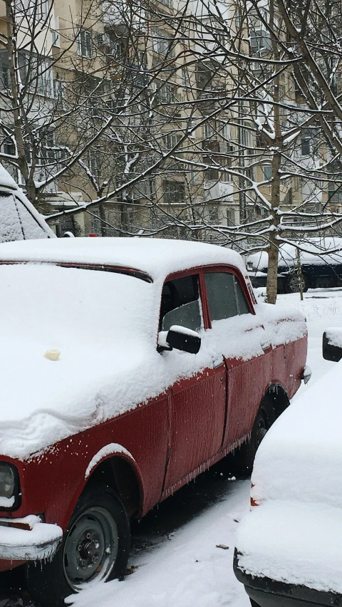 the old truck is parked on a snowy street