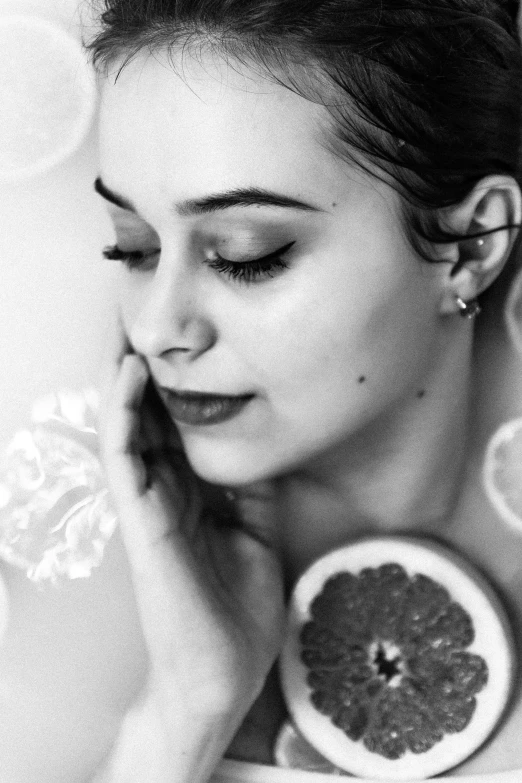 a woman in the shower with an orange in her hand