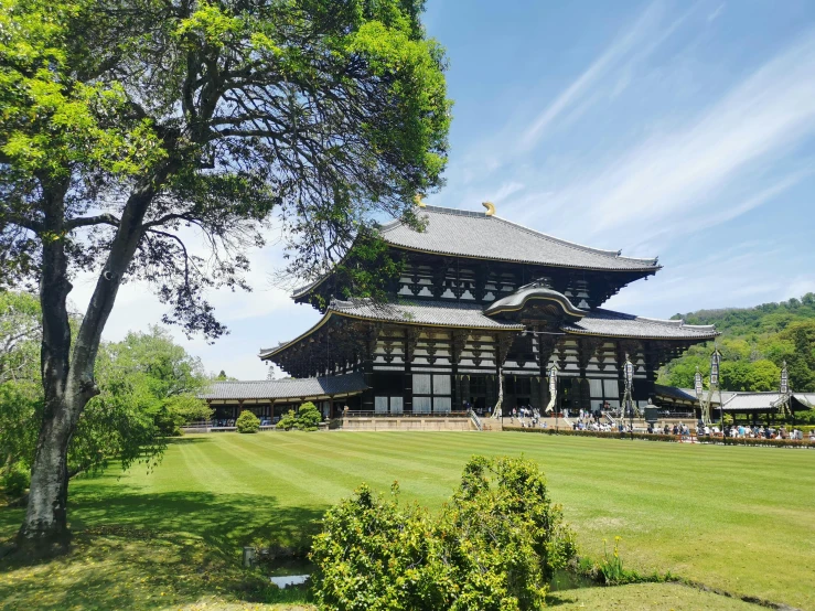 an ornate wooden building standing in the middle of a field