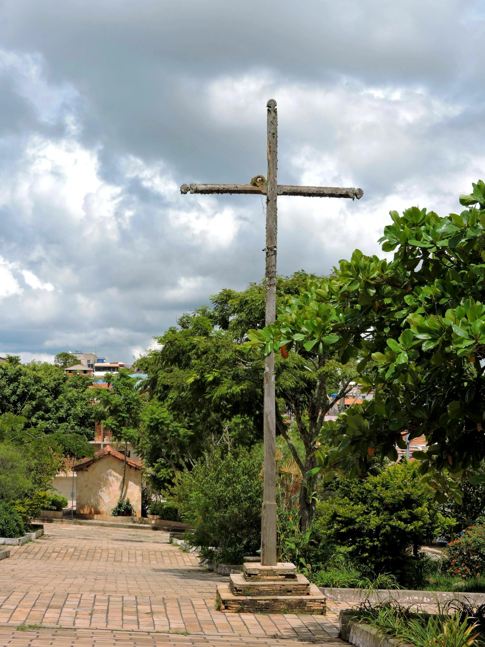 the wooden cross is located on a brick pathway