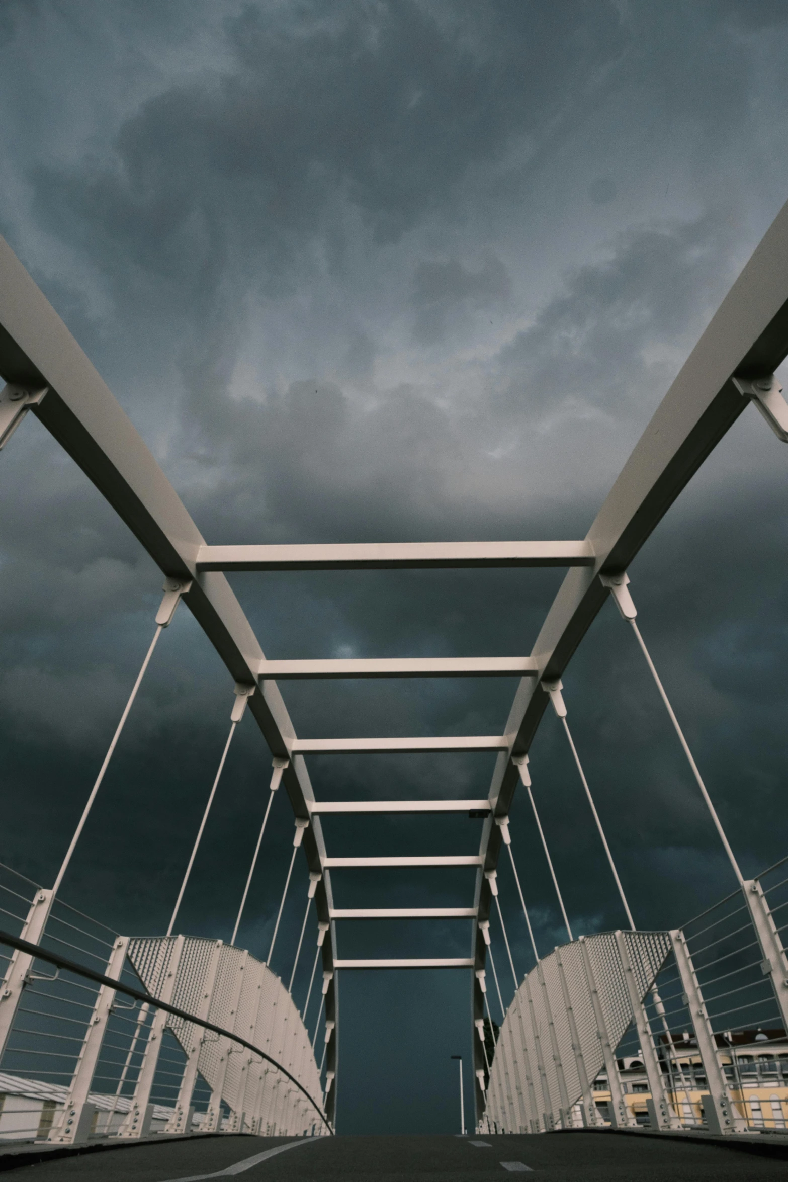 a bridge with some dark clouds and dark skies