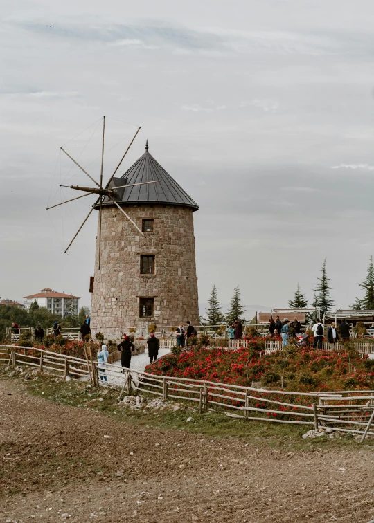 people standing near a building with a windmill in front