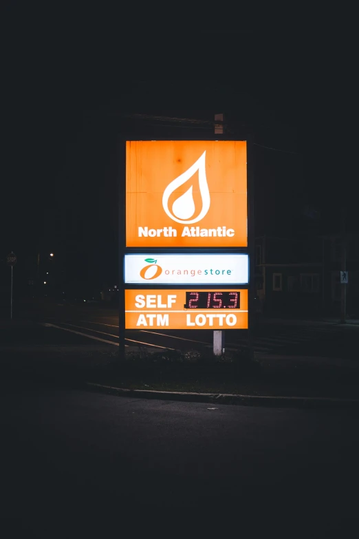 a neon sign sitting on the side of a road at night