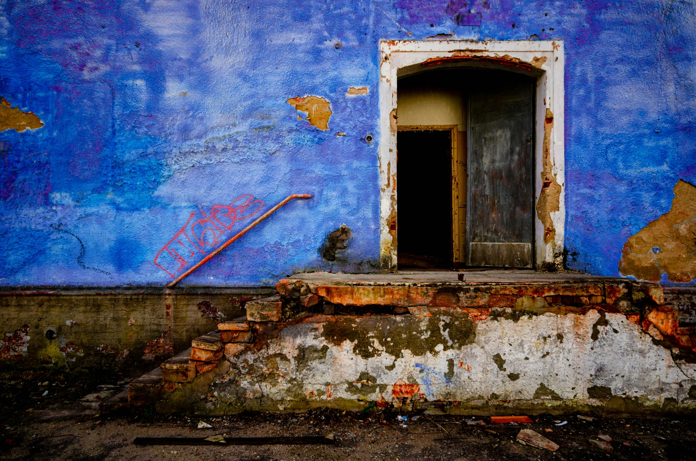 a very dirty door on an old blue building