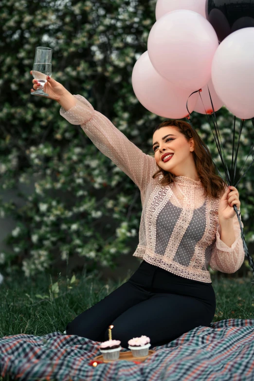 a woman on the grass with some balloons