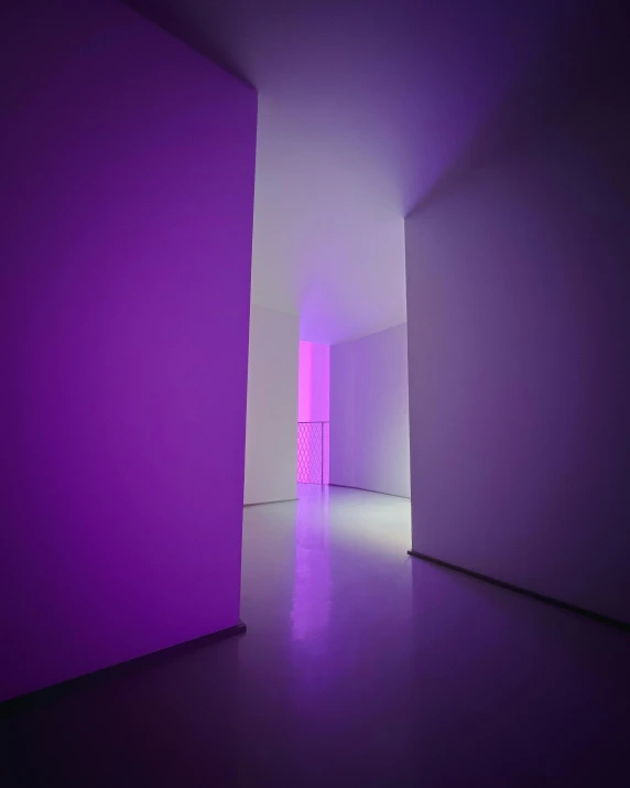 the hallway of a room that is lit by bright purple lights