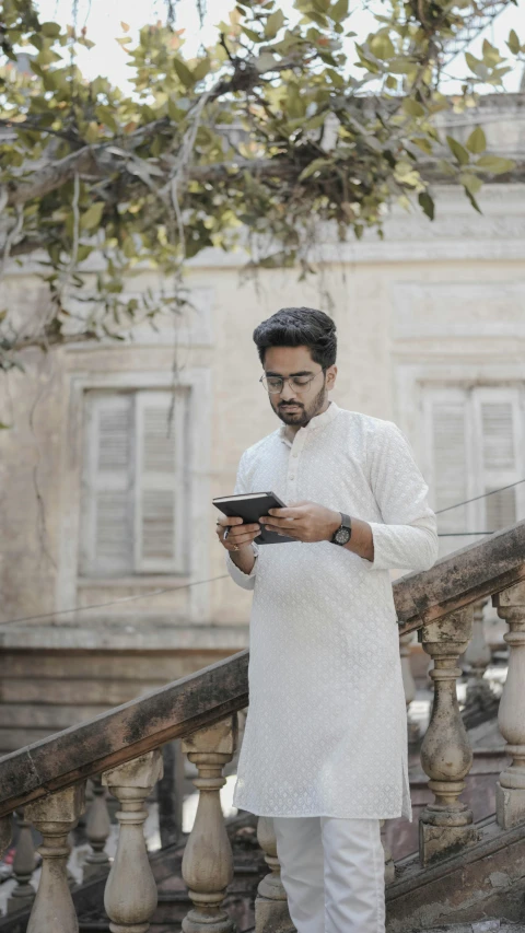 a man walking down a stair case looking at his phone