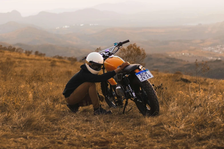 a man riding a motorcycle down a grass covered hillside