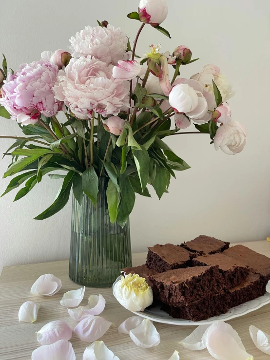 cake with flowers in a vase and some petals