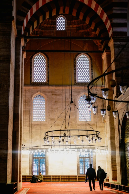 two people walking through the main hall of a building