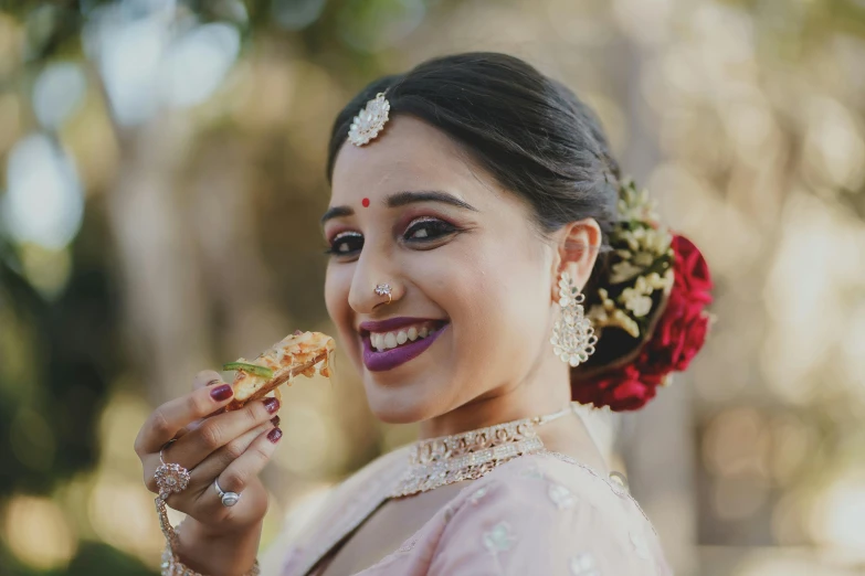 an indian woman in traditional garb eating some food