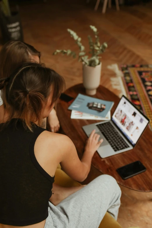 a woman sitting on the floor on her laptop