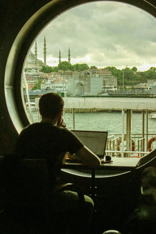 a person sitting at a table working on a laptop