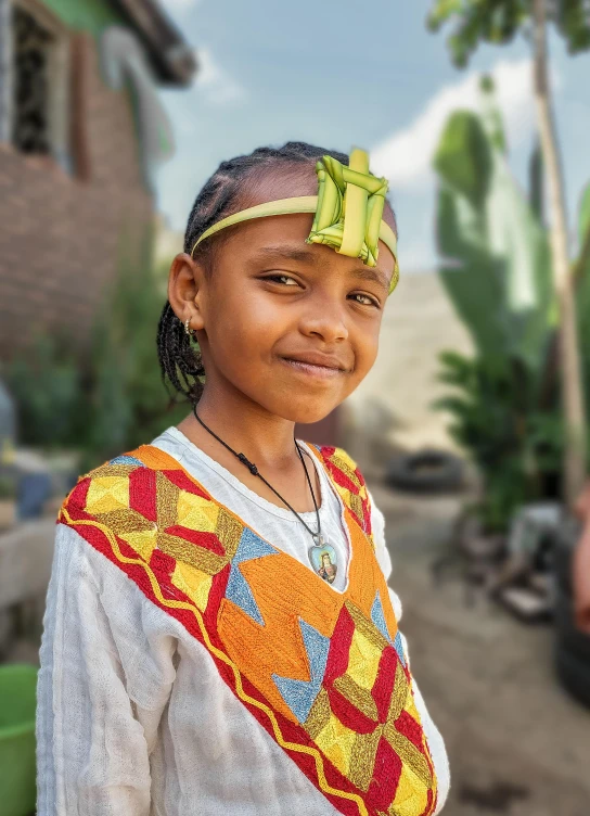 a young child wearing a colorful cloth vest