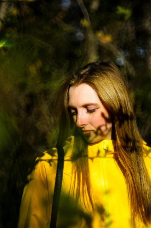 a woman wearing a yellow jacket is looking down