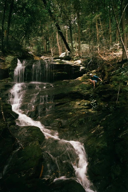 there is a man standing by a stream of water