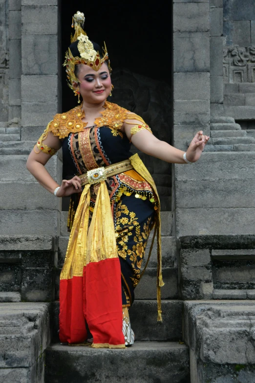 a woman in colorful costumes standing on steps