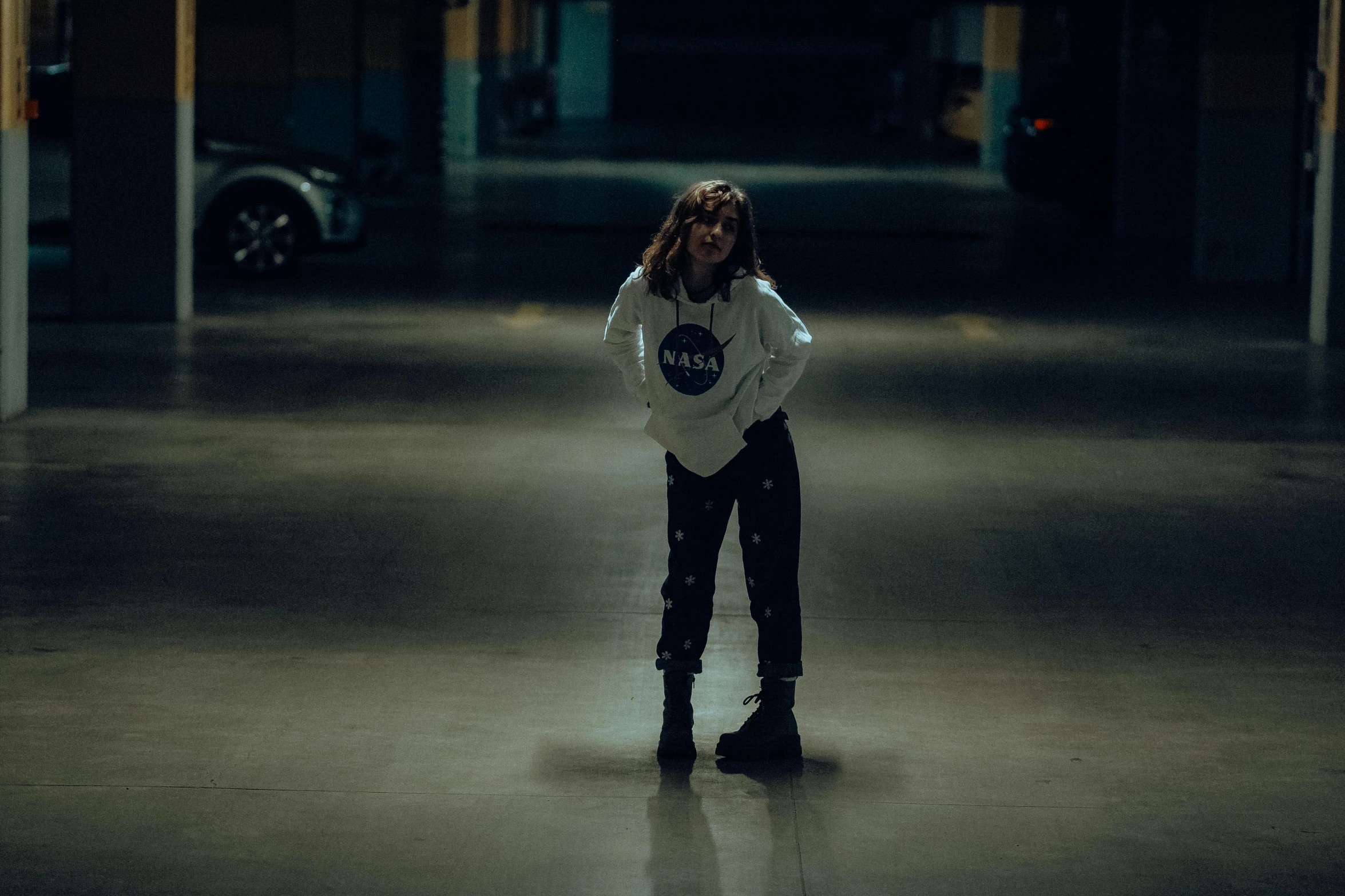 a girl is standing on the street while talking on her phone