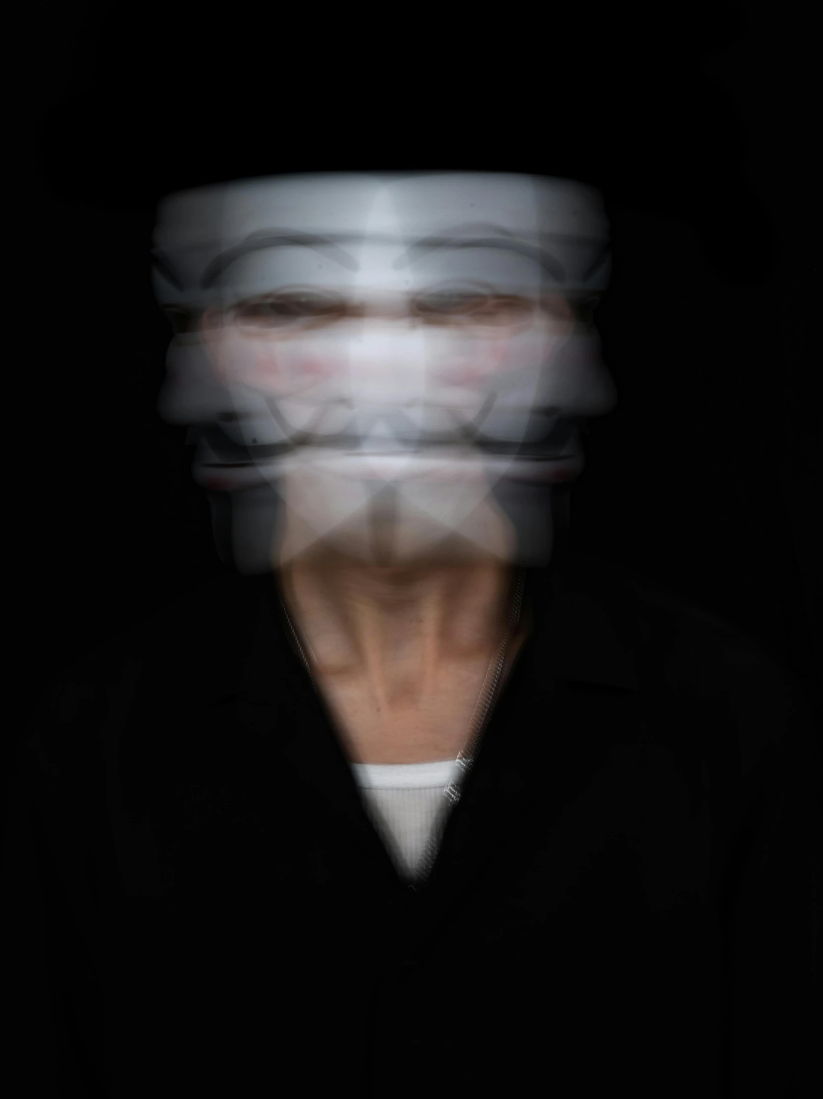 an image of blurry man with face obscured in black background