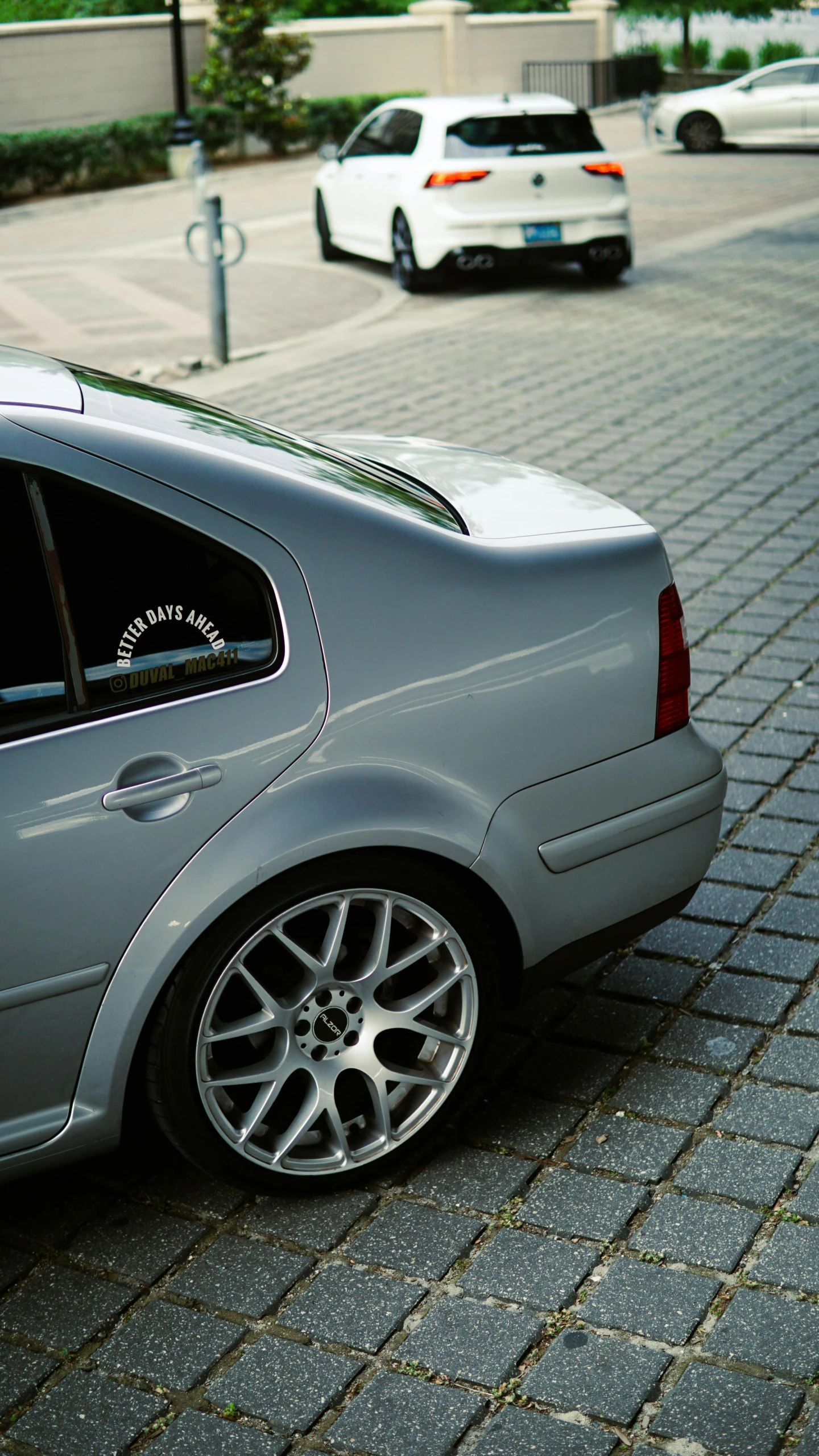 the silver car is parked on the side of the road