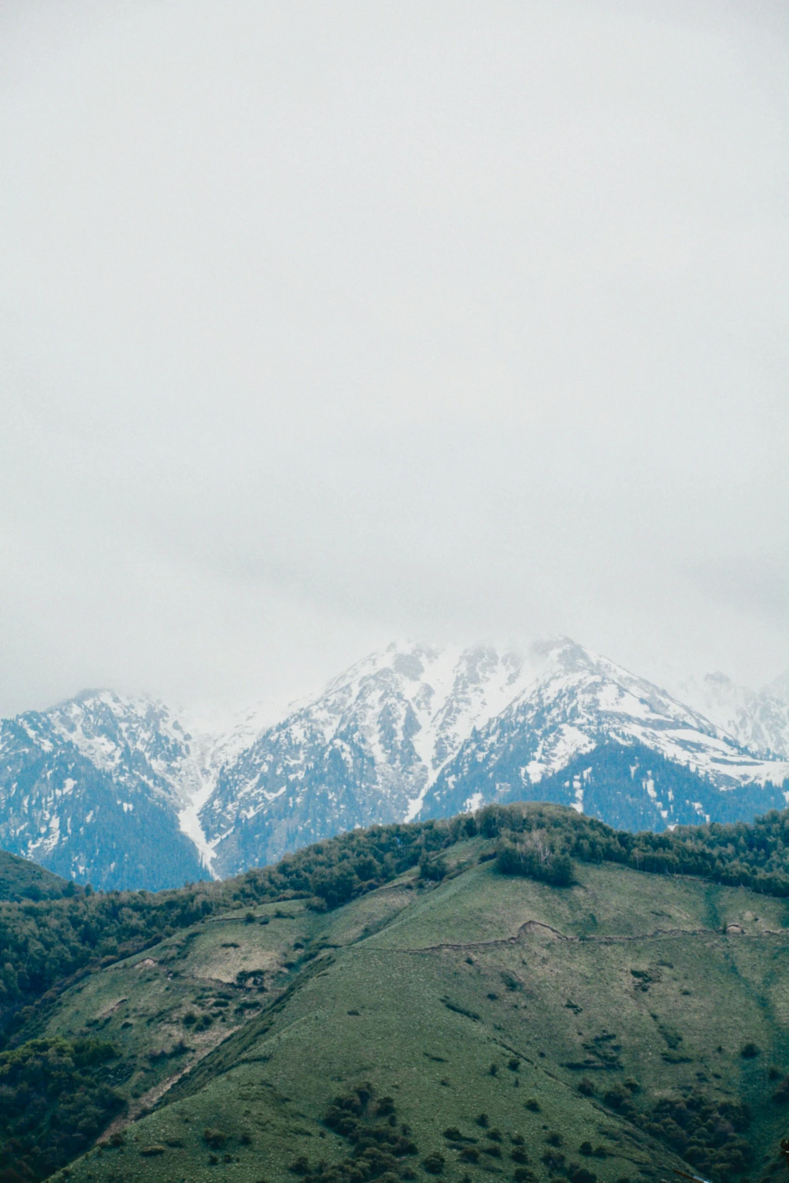 some snowy mountains are shown in this cloudy sky