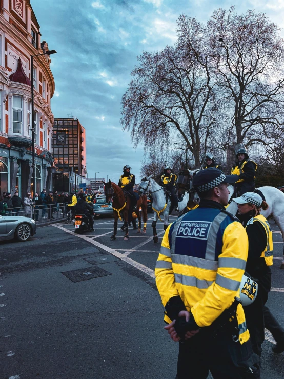 a street scene with police officers and horses in the foreground