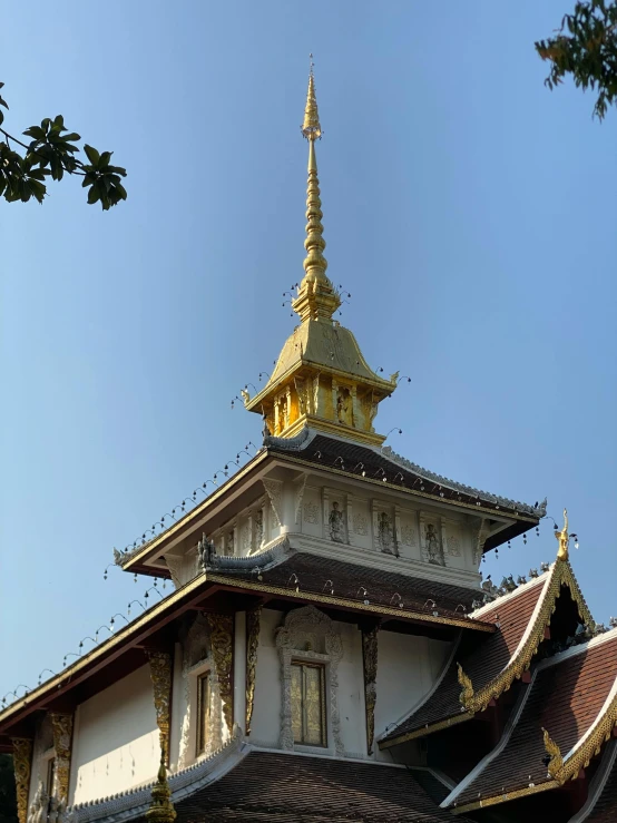 the building is white with a gold and white steeple