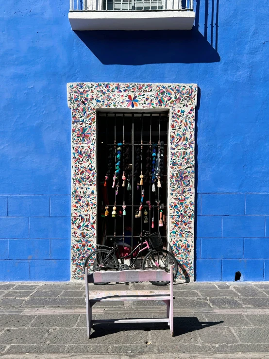 a bench sitting in front of a blue building