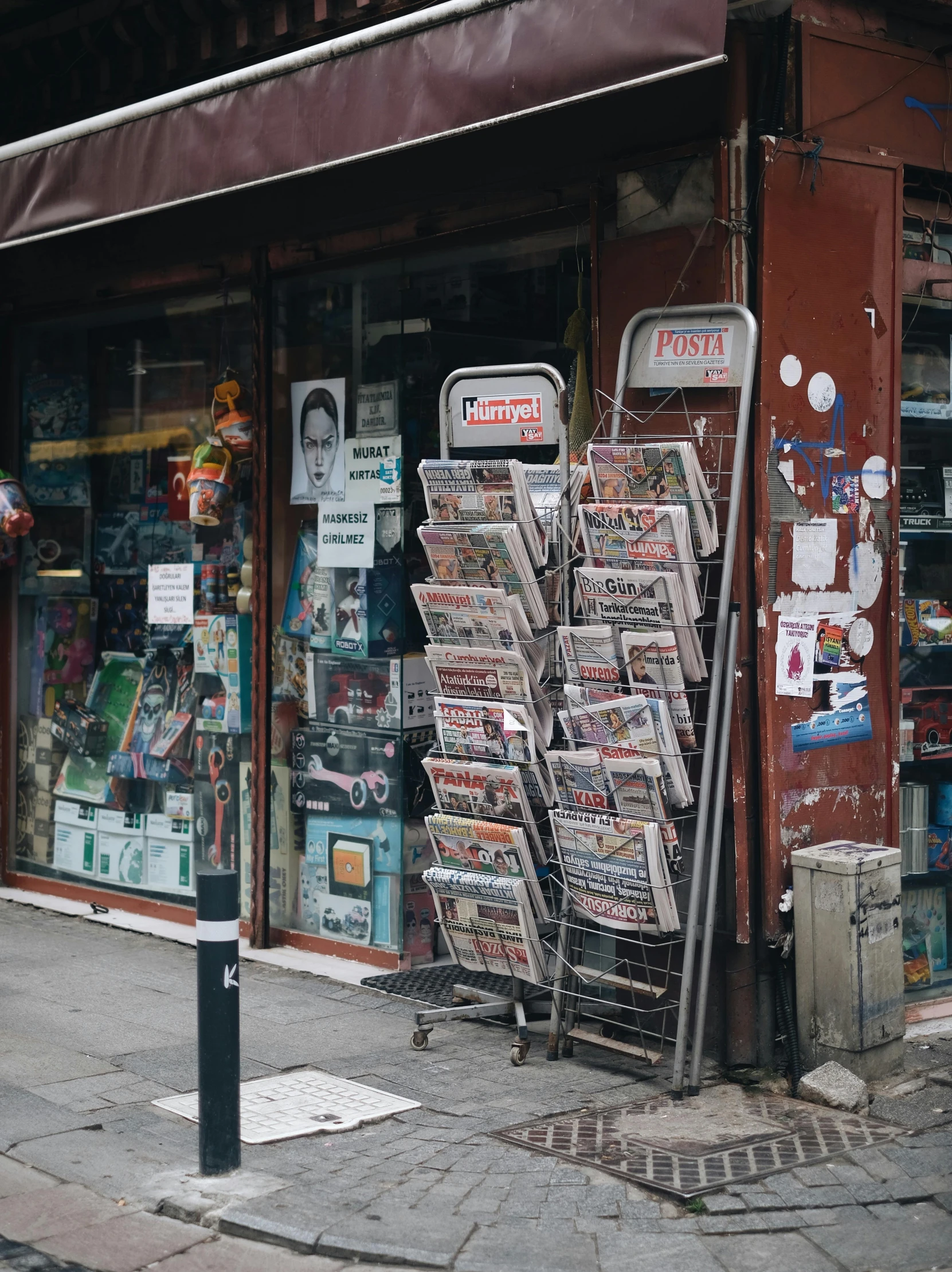 an old newsstand sitting next to the side of a street