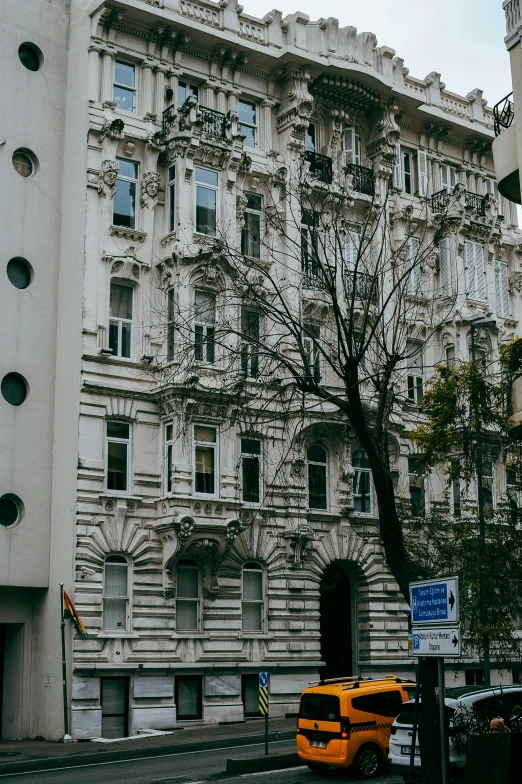 an old building with a yellow bus sitting in front