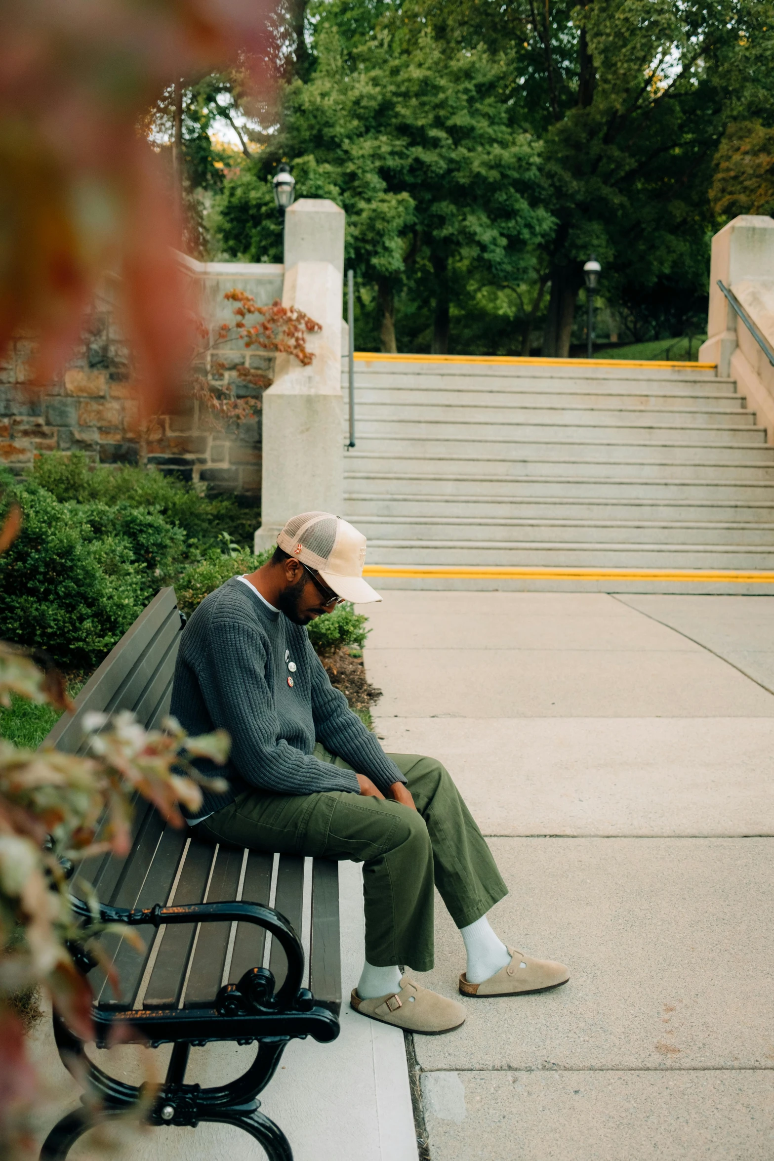 a man sits on a bench in front of some stairs