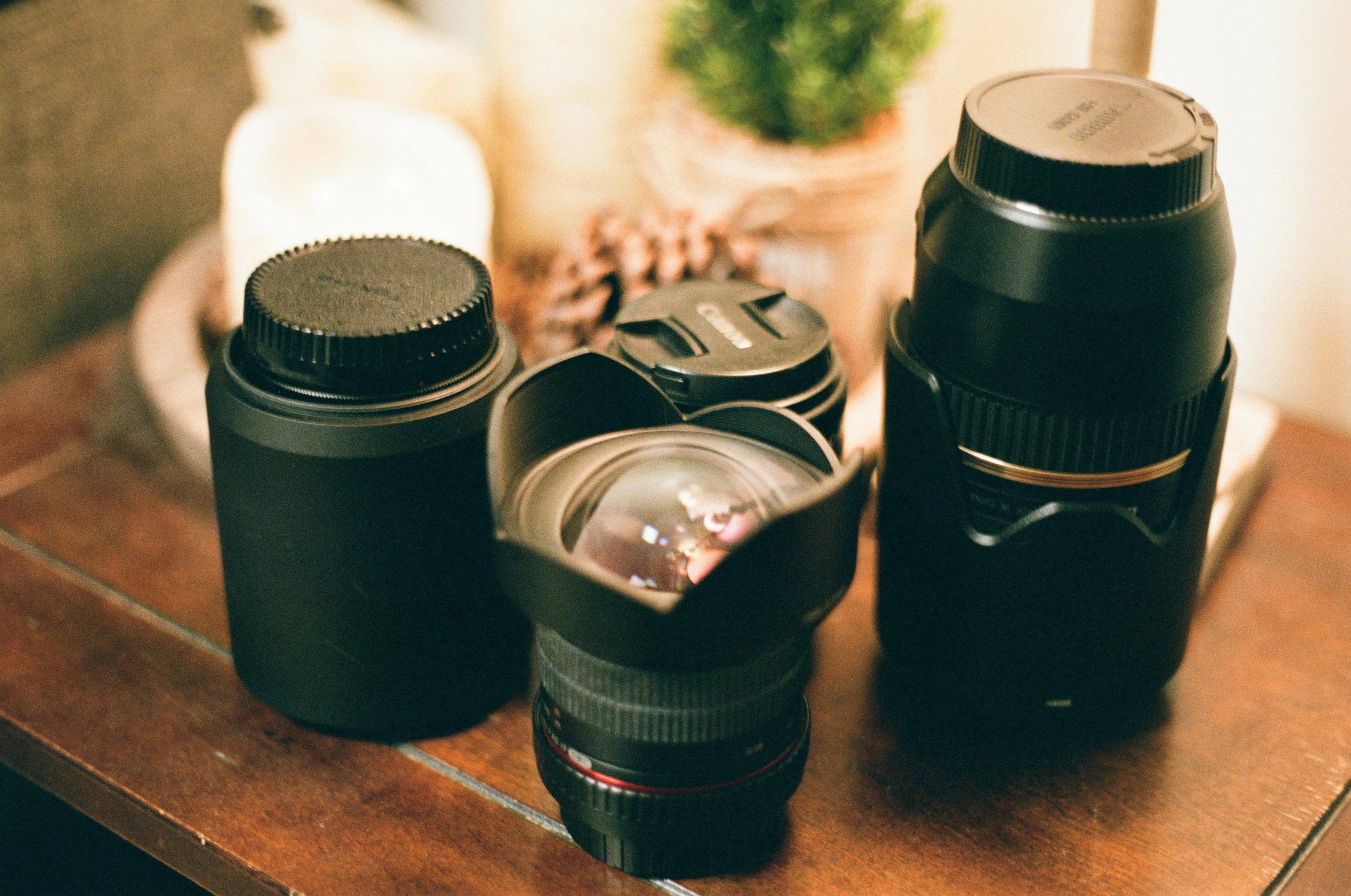 three different styles and sizes of camera lenses sit on a table