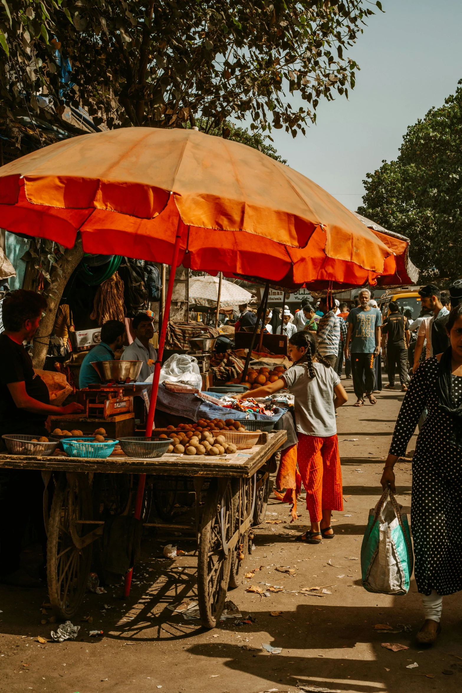 the people are walking around at a market selling products