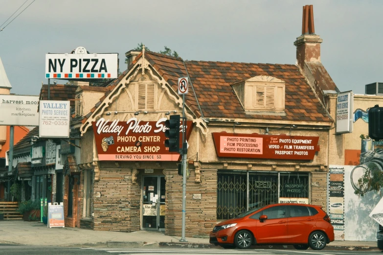 small red car parked in front of a store