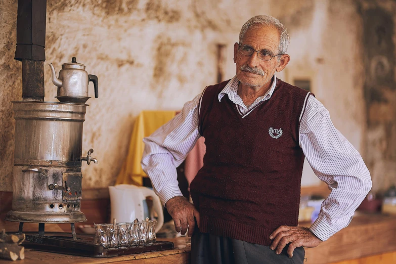 an elderly man stands in the kitchen next to a stove