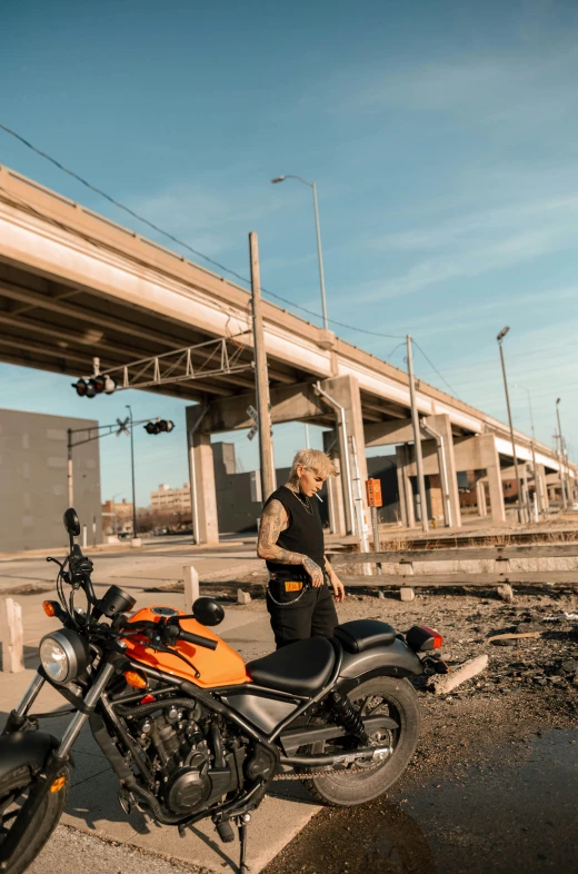 woman stands by her motorcycle and looking away