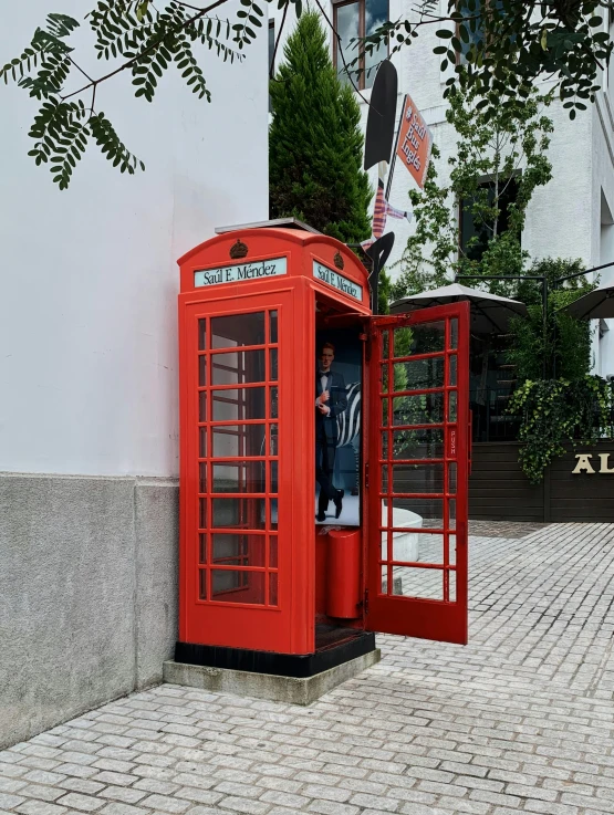 a man standing inside of a phone booth