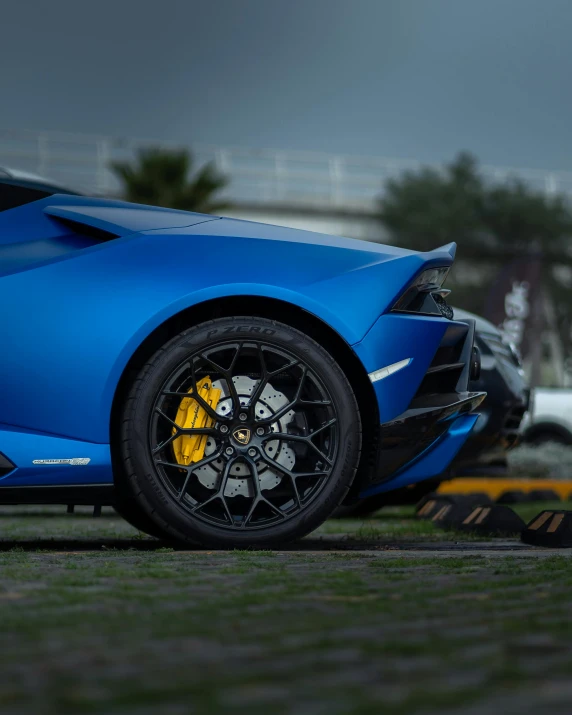 a blue sports car parked in the grass