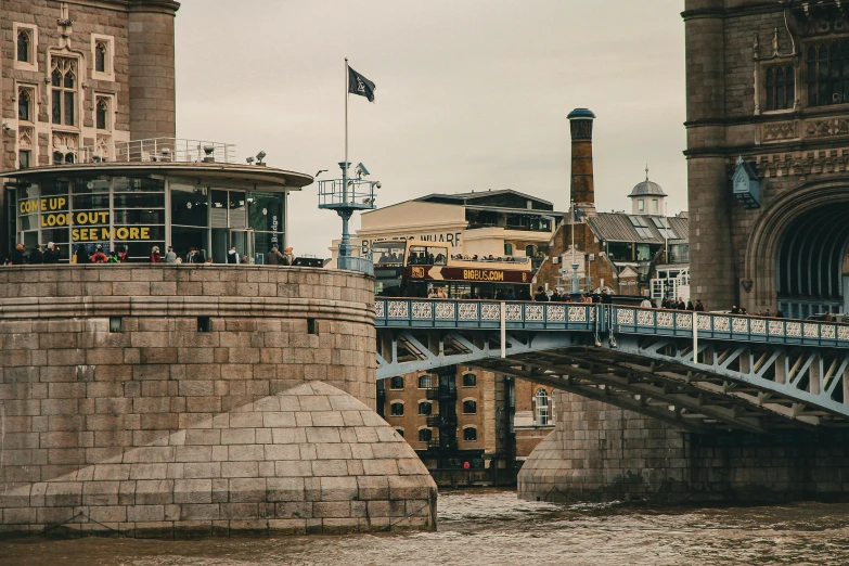 the people are outside on the bridge near the building