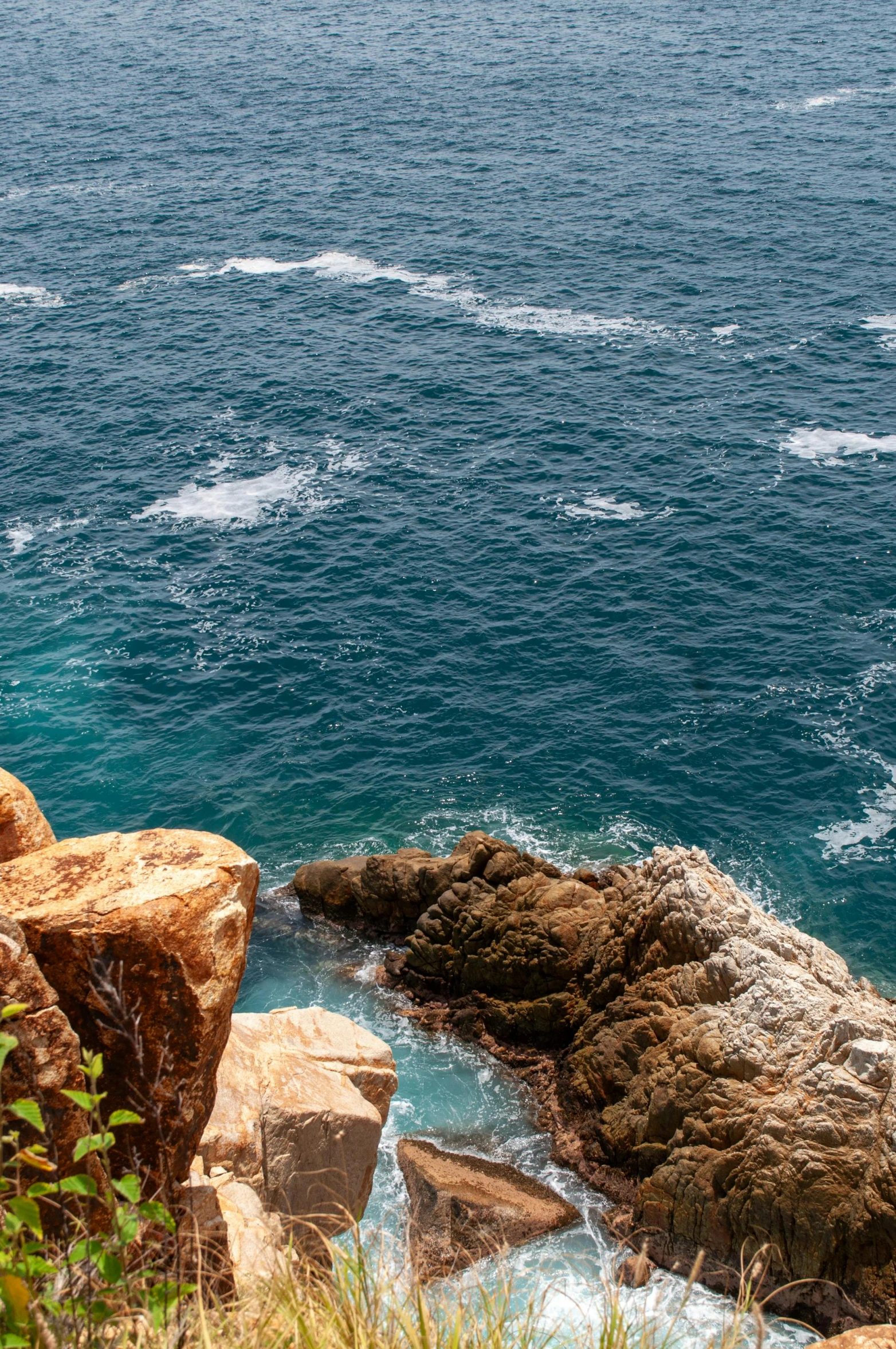 a man standing on top of a large cliff next to a body of water