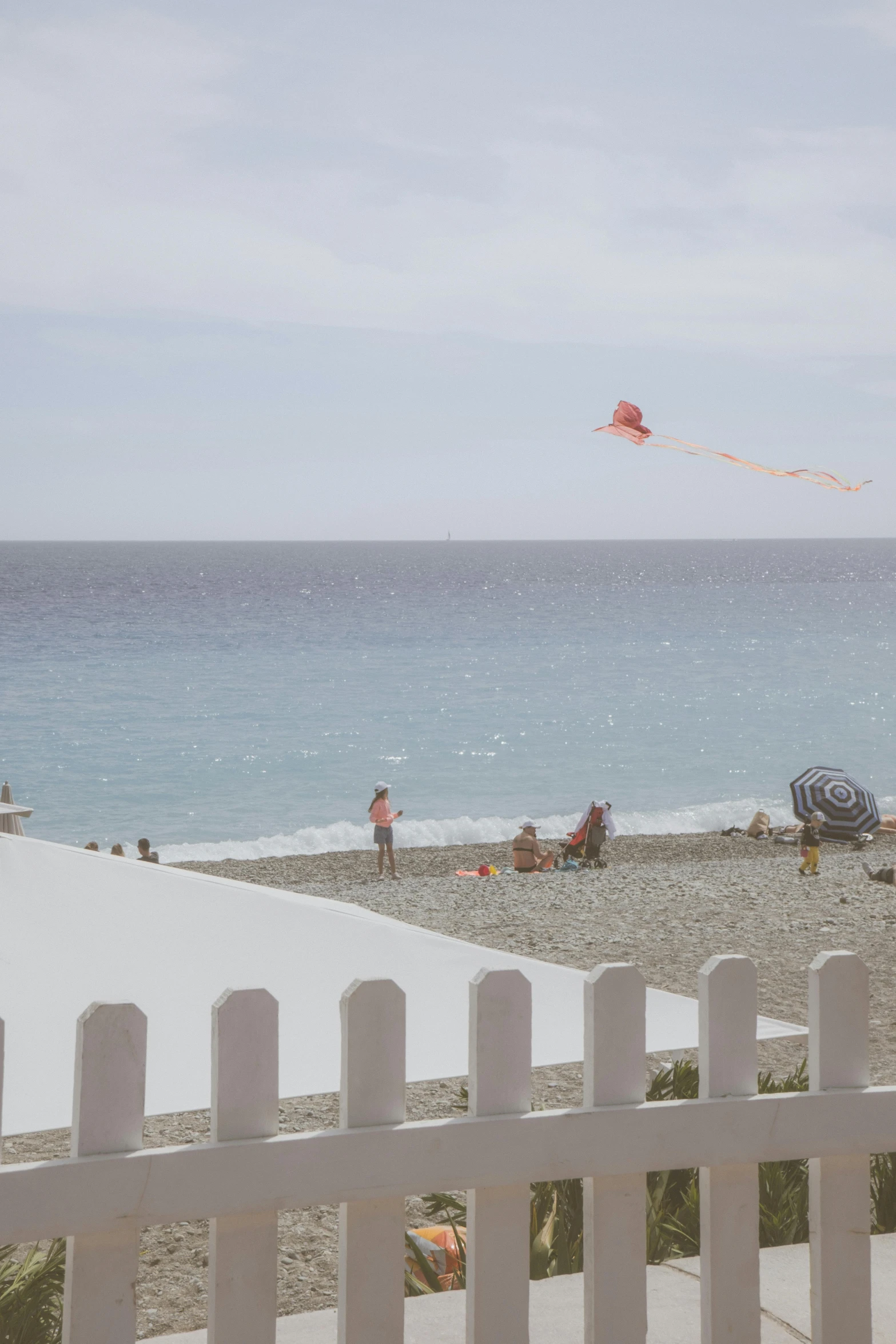 people are on the beach watching a kite